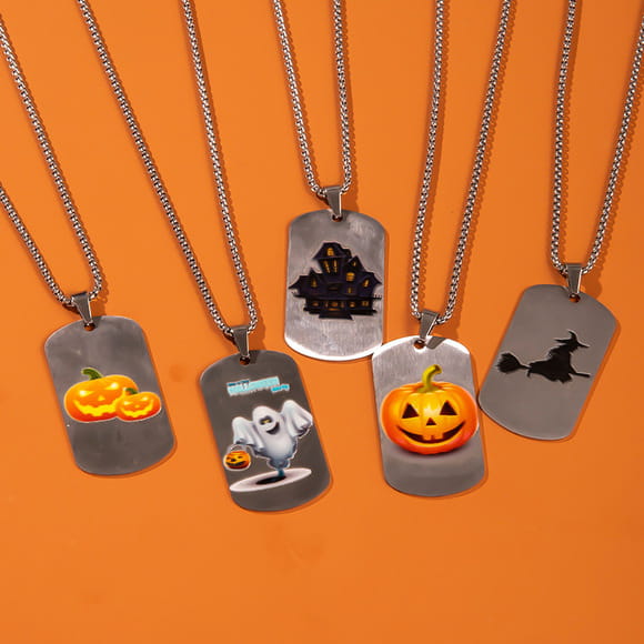Set of five silver-toned dog tag necklaces featuring unique Halloween-themed designs including pumpkins ghosts haunted houses and witches for festive beaded jewelry use.
