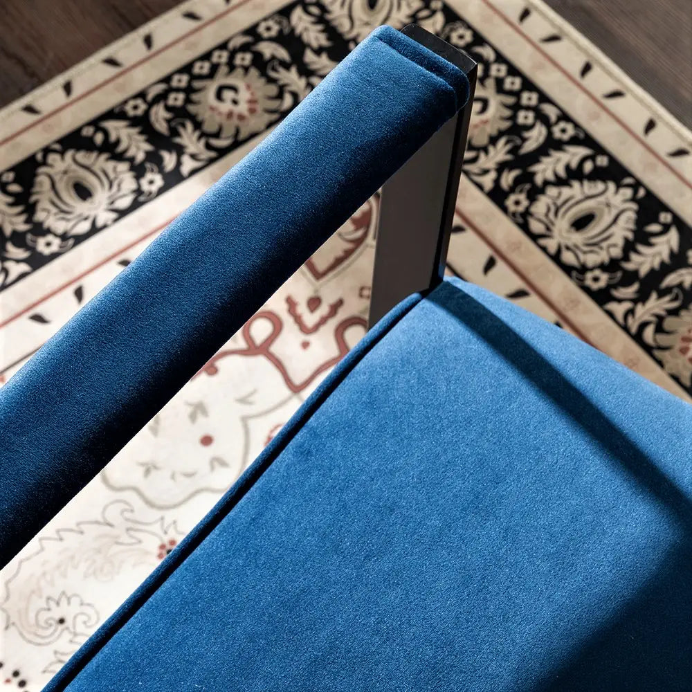 Deep blue velvet accent chair with a sleek black metal frame shown from the front.