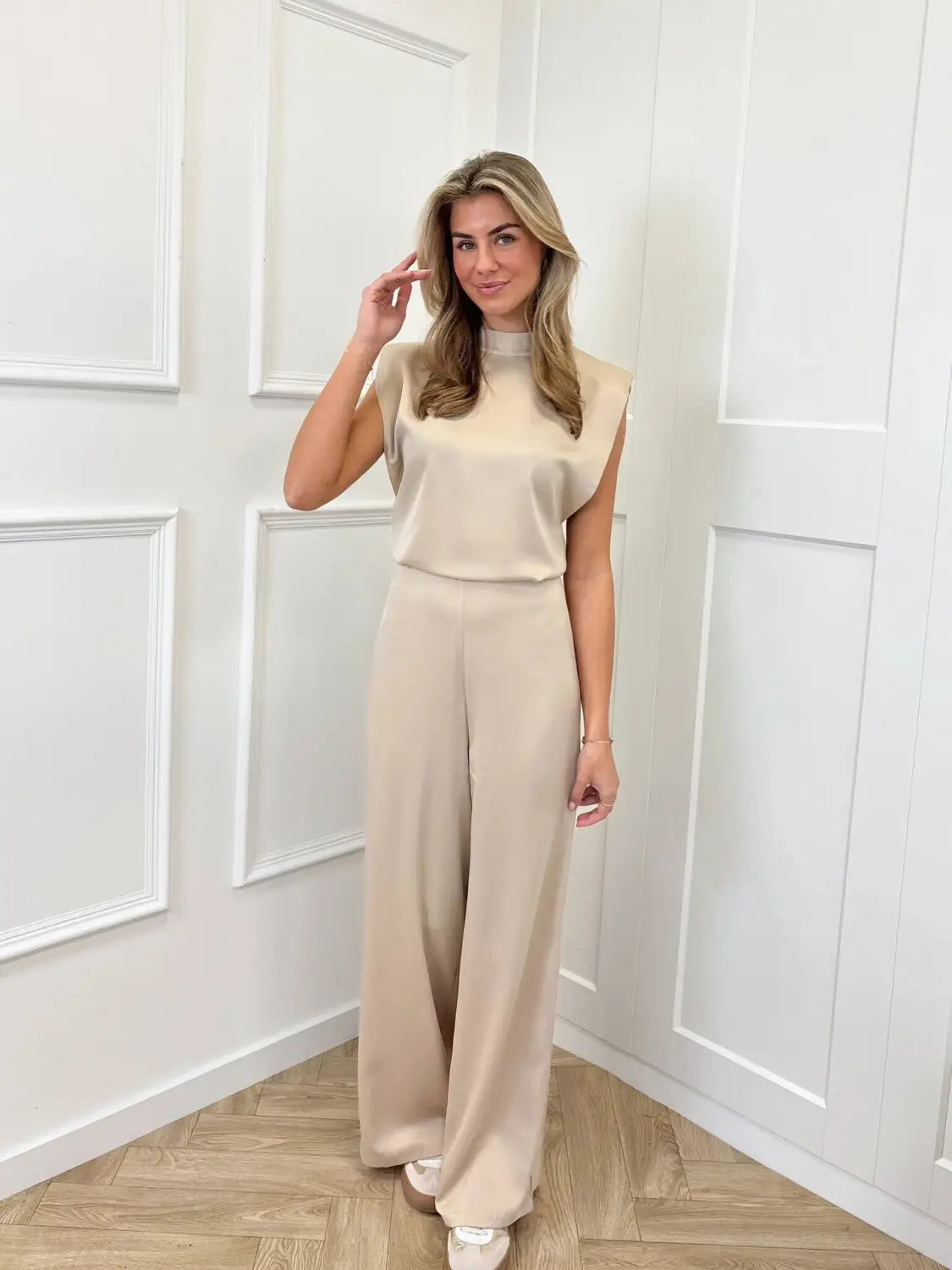 Beige sleeveless high-neck backless evening dress jumpsuit with wide-leg straight pants made of smooth flowing fabric.