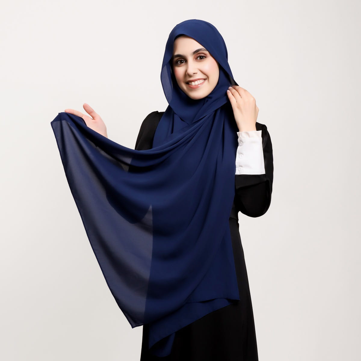 Un hijab en mousseline légère bleu marine, avec un tombé doux et une légère brillance provenant de la collection hijab magnétique en mousseline couleur unie kaki.