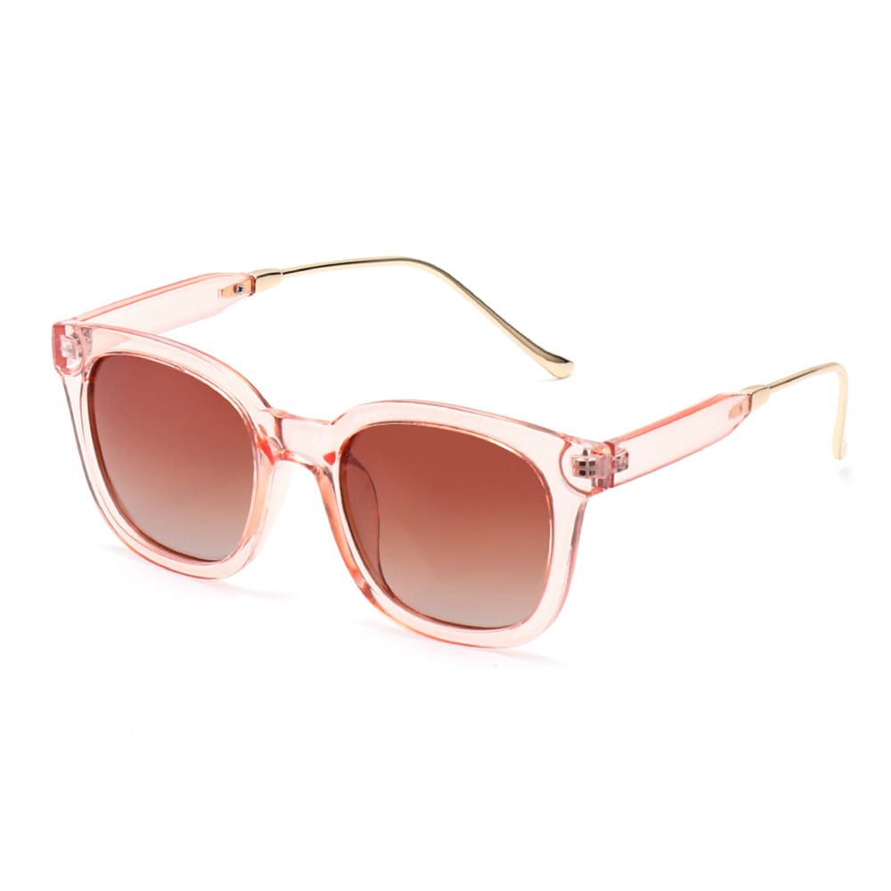 Lunettes de soleil carrées polarisées pour femme présentant des montures translucides roses, des verres dégradés bruns et des branches métalliques ton sur ton doré.