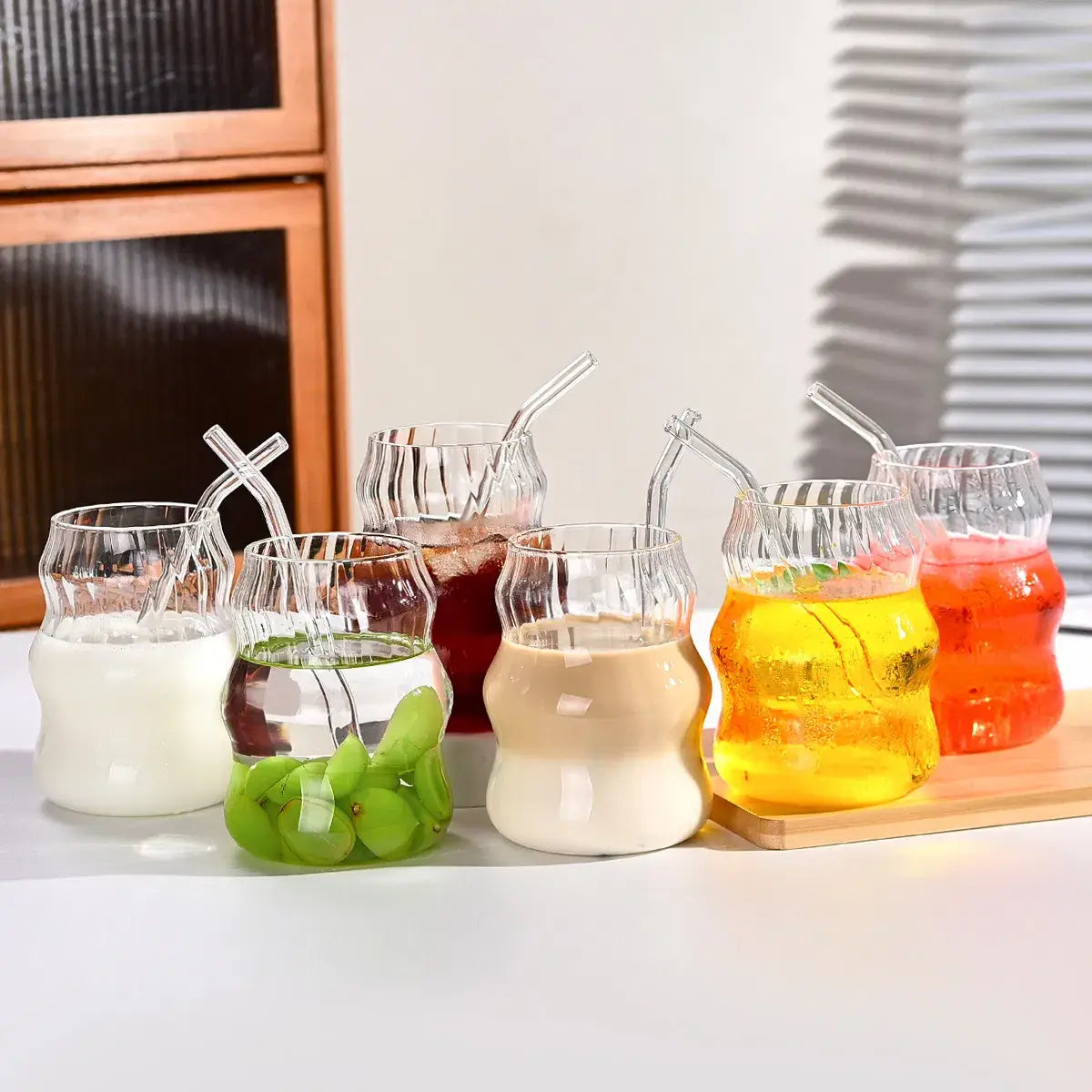 Set aus sechs klaren Glasbechern mit einzigartigen gewellten gerippten Formen und passenden transparenten Glasstrohhalmen in einem 19-oz-Design.
