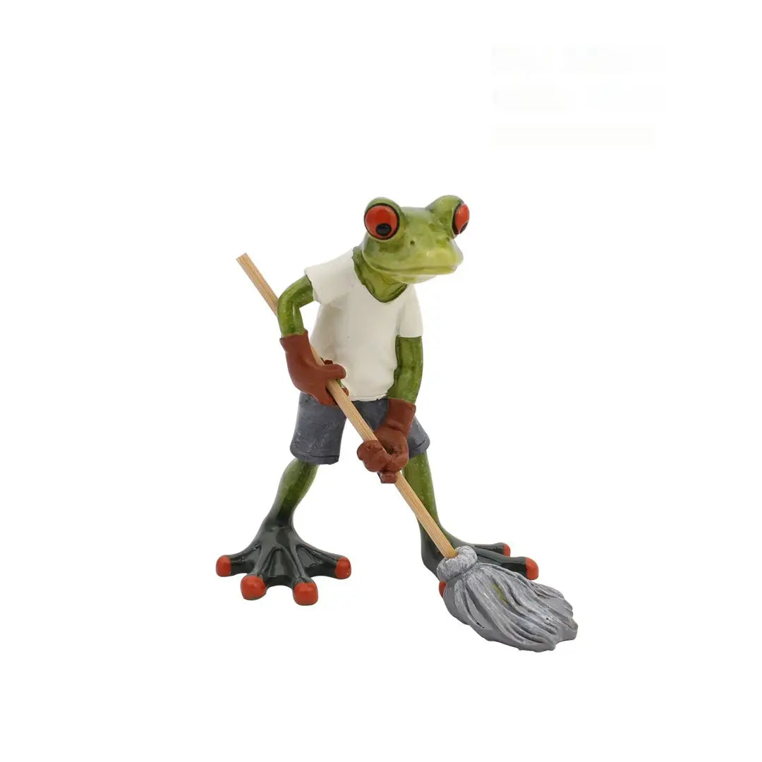 Grüne Frosch-Resinfigur, die ein weißes T-Shirt und graue Shorts trägt, hält einen grauen Wischmopp mit Holzgriff für skurrile Wohnaccessoires-Statuen.