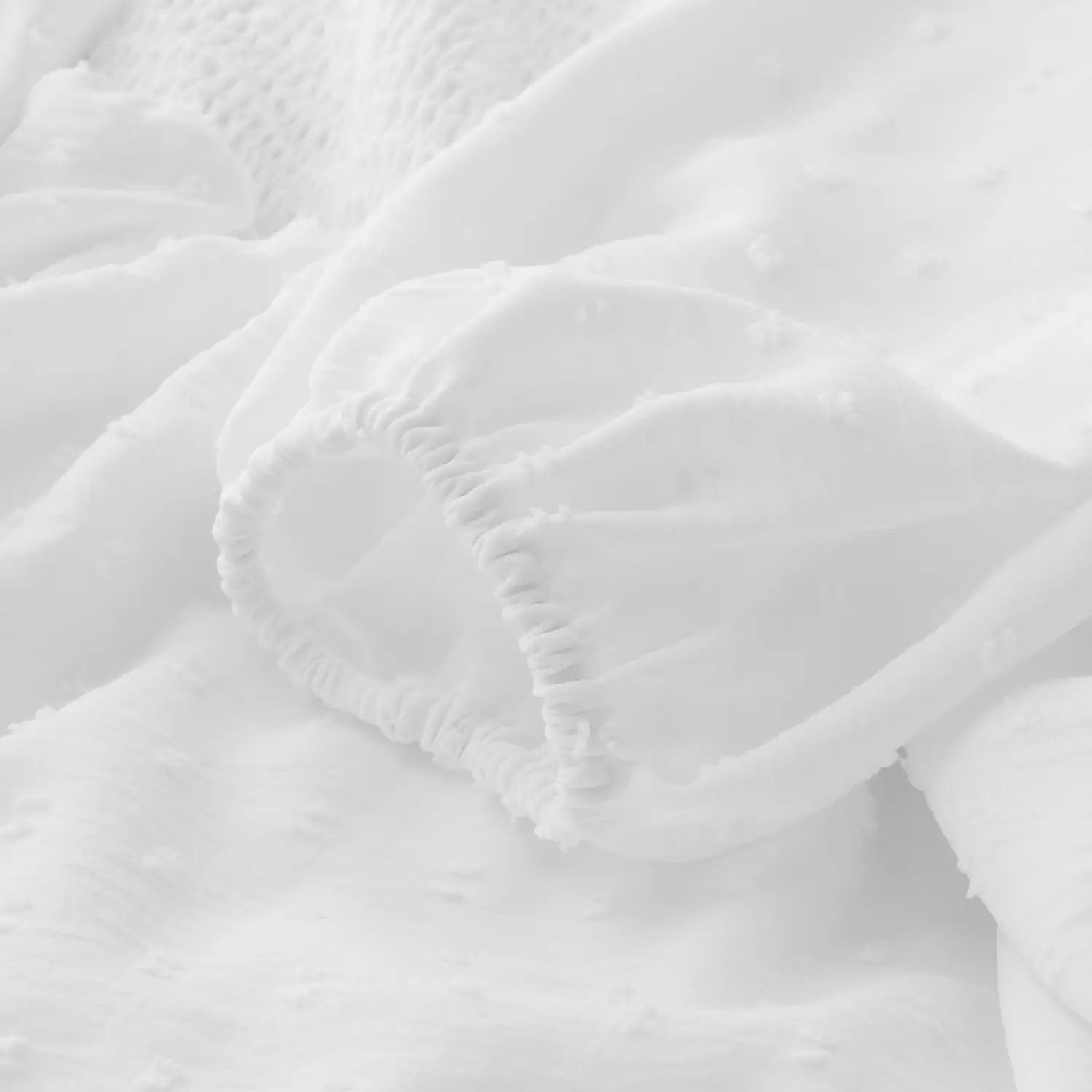 Off shoulder long sleeve ruffled tiered mini dress in white soft textured fabric with delicate ruffled edges and subtle lace detailing.