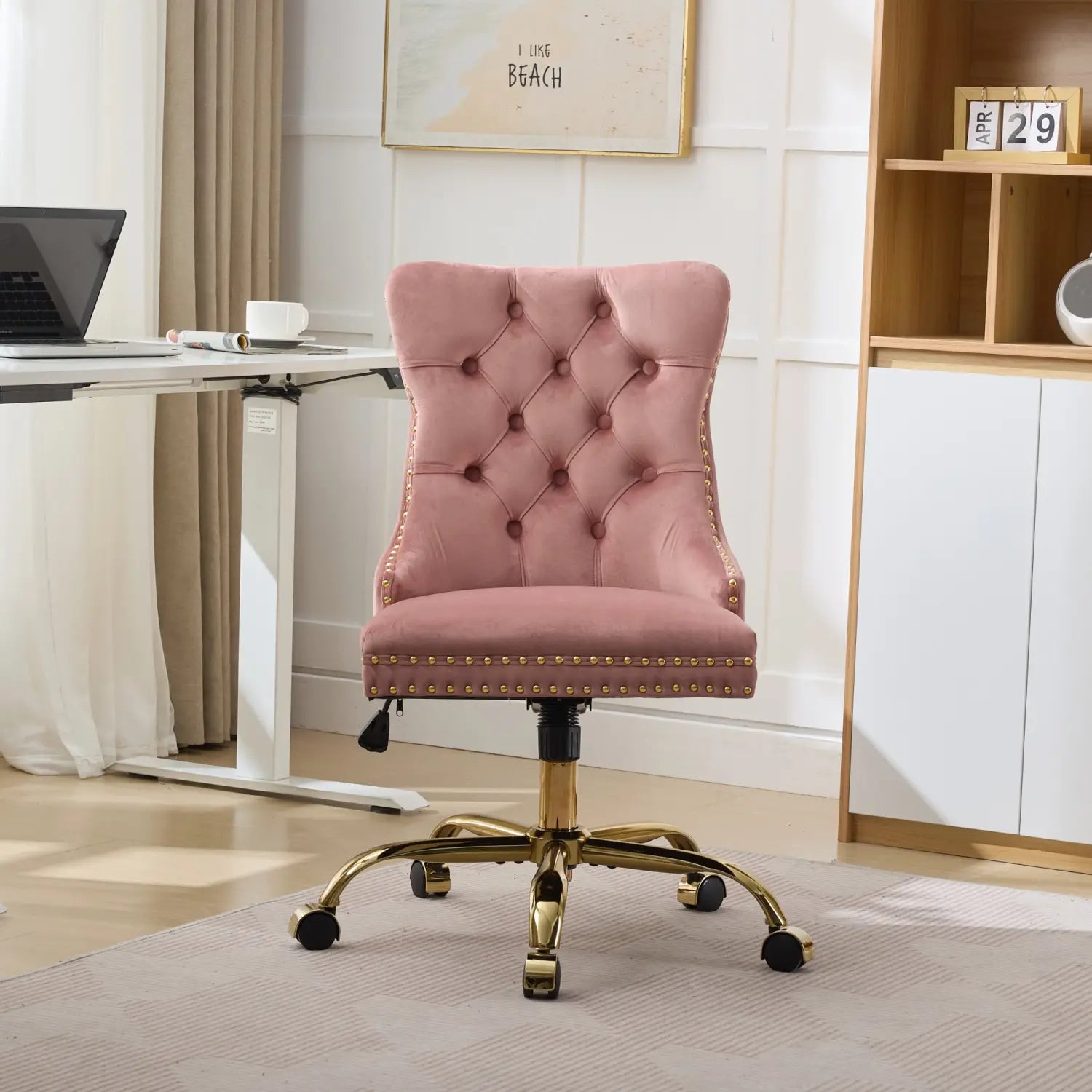 Fauteuil de bureau en velours rose poudré à capitonnage avec monture et base métalliques ton doré, conçu pour un usage au bureau.