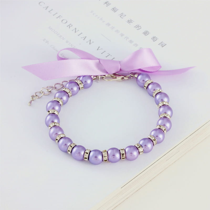 collier délicat en ruban pastel, sous la forme d’un collier de perles pour animal en perle lavande, orné d’accents de strass à finition argentée et d’un nœud en ruban de satin assorti.