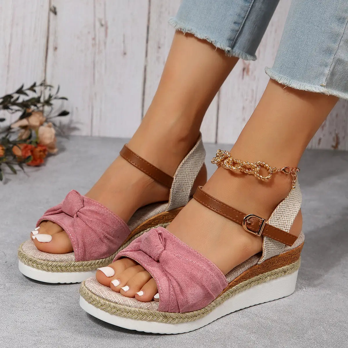 pink suede bow-front wedge sandals with brown leather buckle straps and woven espadrille rope sole