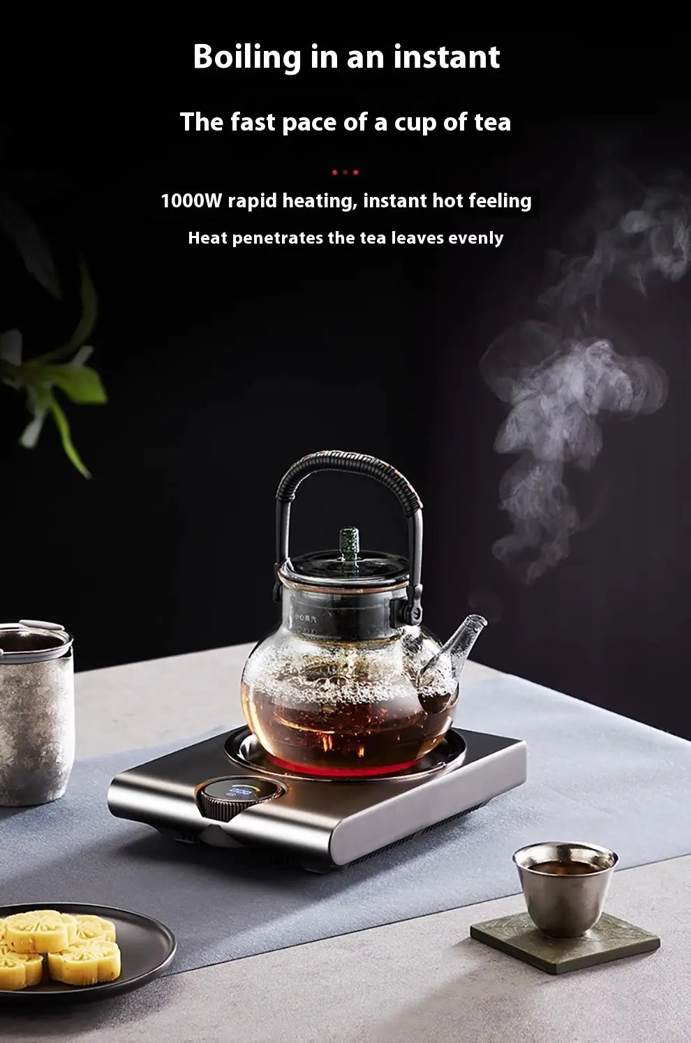 Clear glass teapot with black metal handle and lid on a silver electric ceramic stove 1000w tea cooker kettle.
