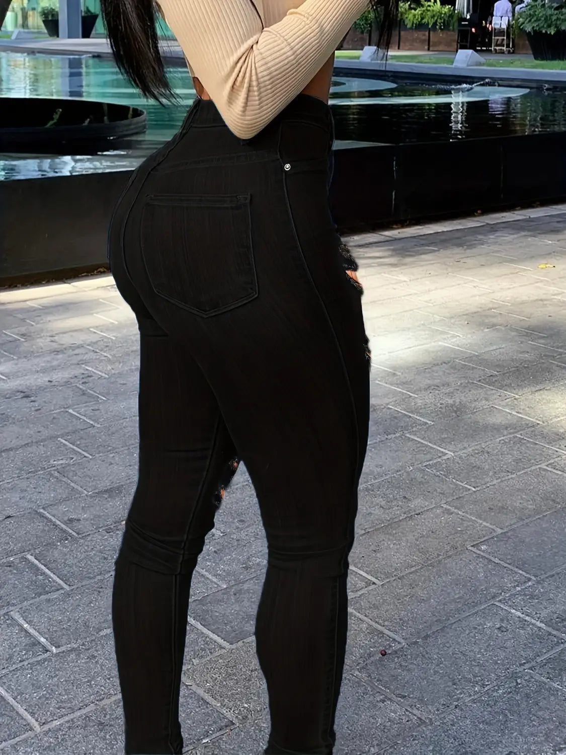 Jeans skinny taille haute échancrés noirs fabriqués en denim, avec des détails délavés de couleur noire