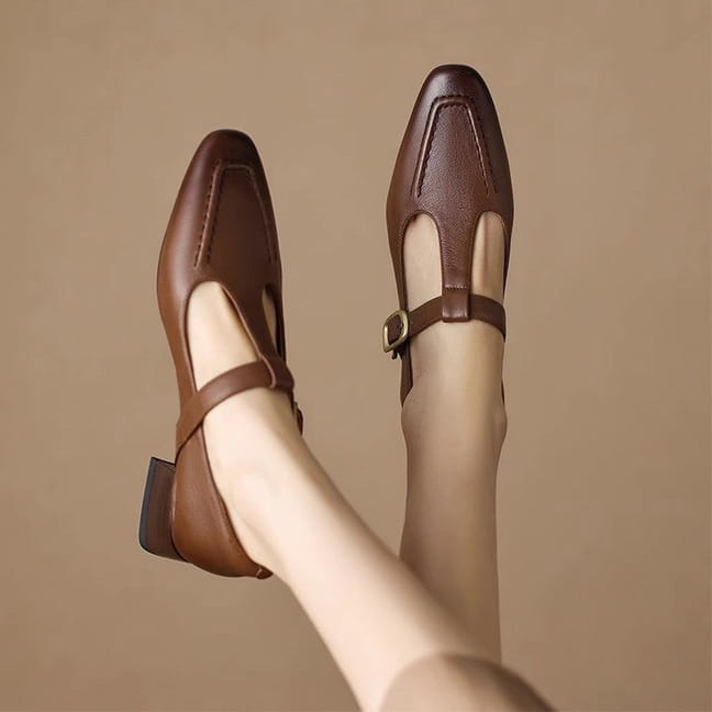 Zapatos tipo Mary Jane de cuero marrón con puntera cuadrada y correa de tobillo en un diseño de correa en T.