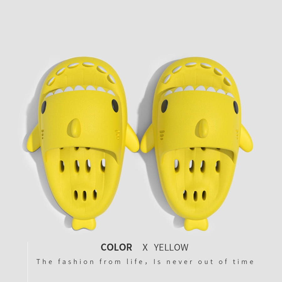 Bright yellow shark slippers with black eye details feature a playful perforated quick dry design and non slip soles ideal for shower use.