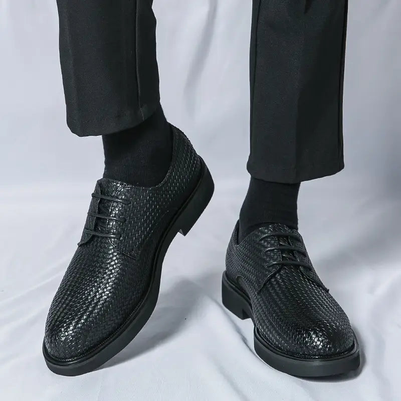 Men’s woven leather platform British dress shoe in black with lace-up design and solid rubber sole.