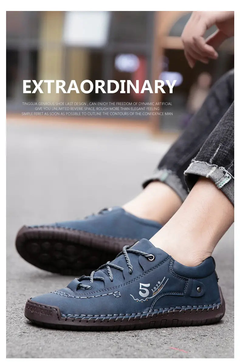 Herren-Lederschuhe im britischen Casual-Stil mit Schnürung aus dunkelblauem Wildleder mit braunen Ziernähten und einem weißen Logo an der Seite.