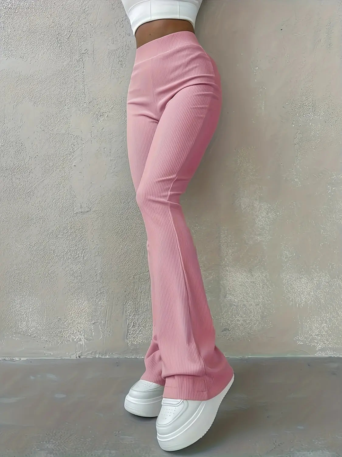Hoch geschnittene Ripp-Flared-Leggings in rosa geripptem Stoff mit einer Vorderansicht und ausgestelltem Bein-Design