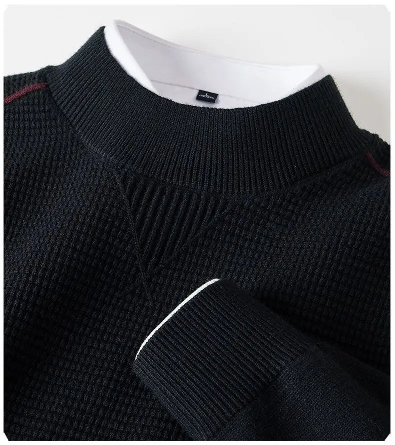 Herren-Pullover aus Strick mit Stehkragen in schwarzem geripptem Stoff mit strukturiertem Oberteil, weißem Innenkragenfutter und dezentem maroonfarbenem Zierbesatz entlang der Schultern.