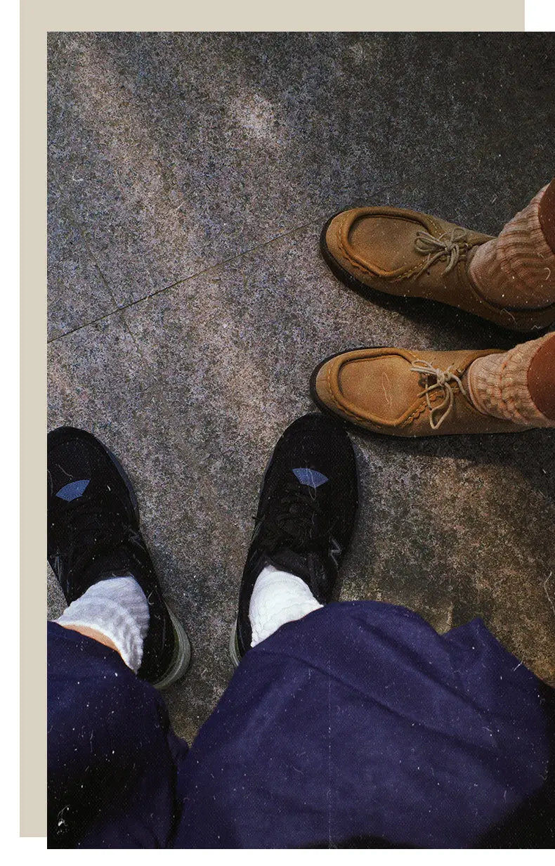 black sneakers with blue accents paired with vintage ribbed cotton long socks for men in white shown from the front.