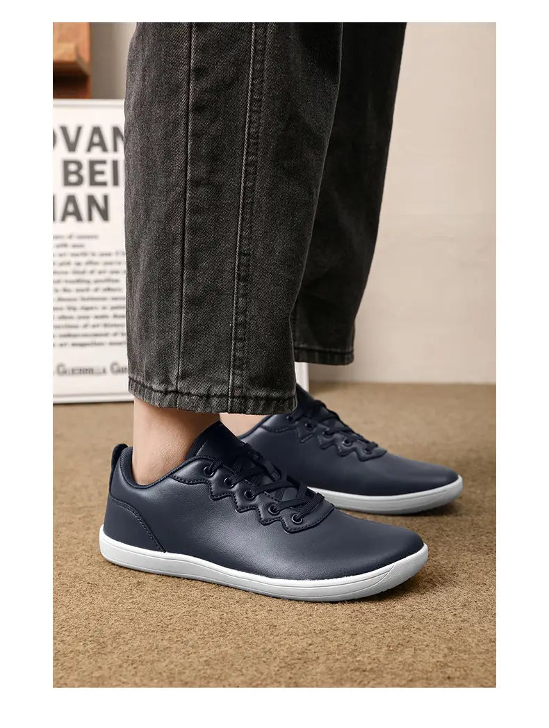 Dunkelblaue Leder-Outdoor-Sneaker mit weißen Gummisohlen und dekorativen Ösen aus Metall für minimalistisches Casual-Wear.
