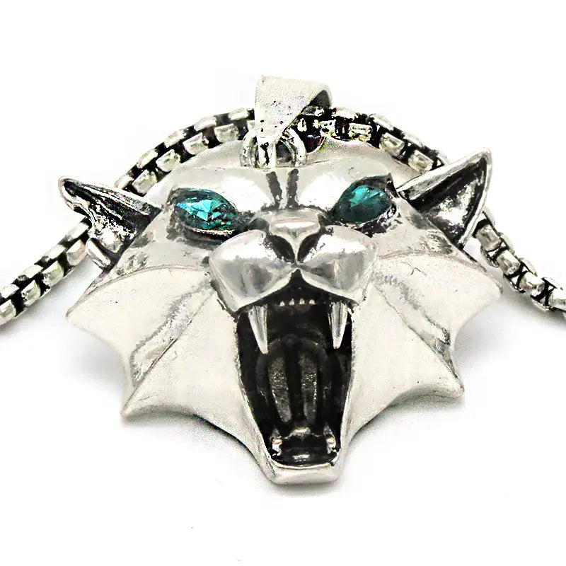Silver panther pendant chain necklace featuring teal gemstone eyes and sharp fangs in a geometric wild game animal design.