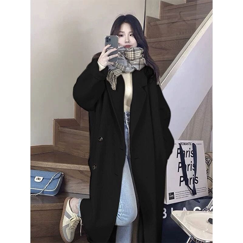black woolen longline trench coat with a classic double-breasted design and button closures shown from the front
