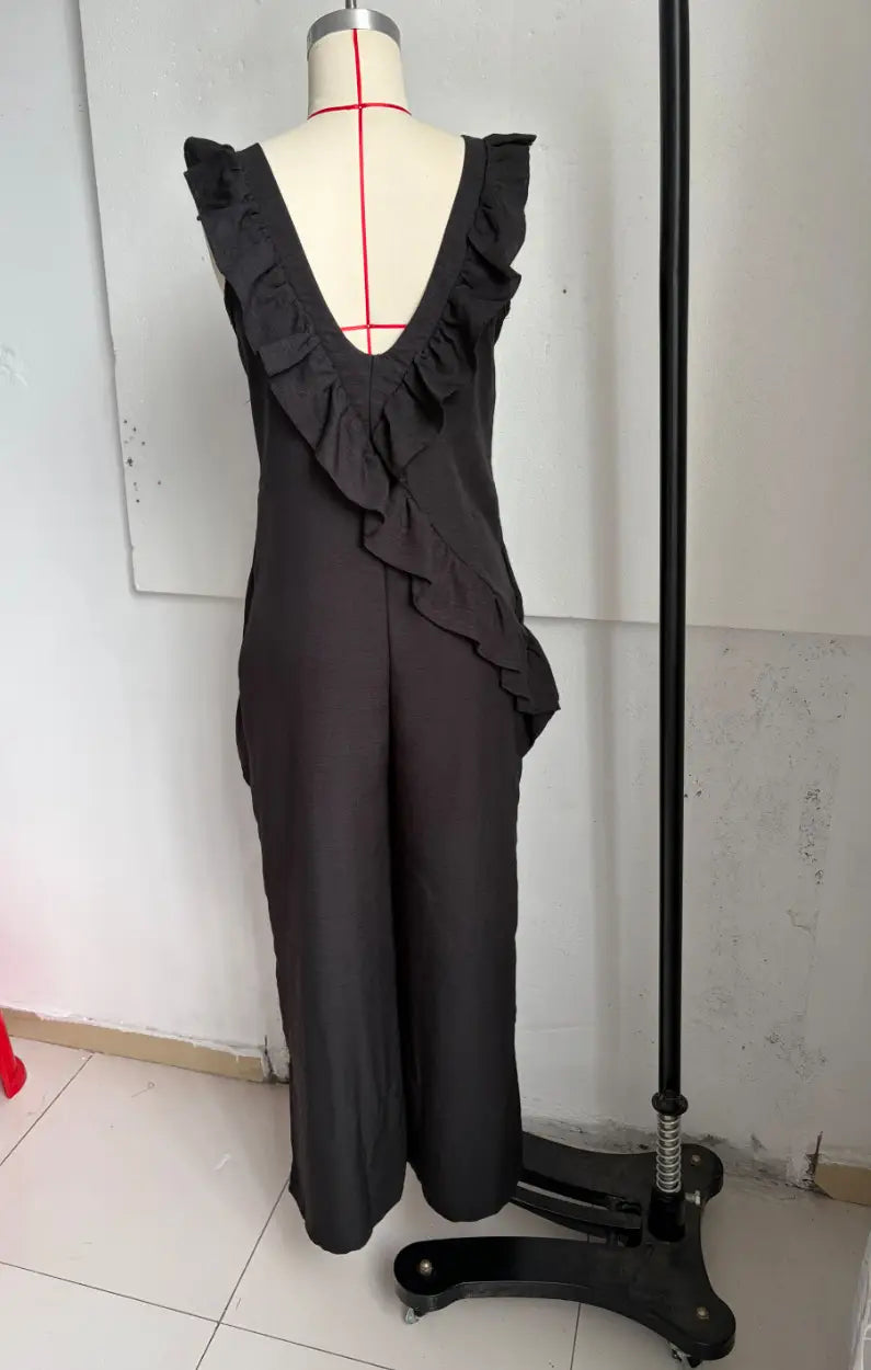Black sleeveless ruffled v-neck resort jumpsuit displayed on a mannequin made from lightweight fabric.