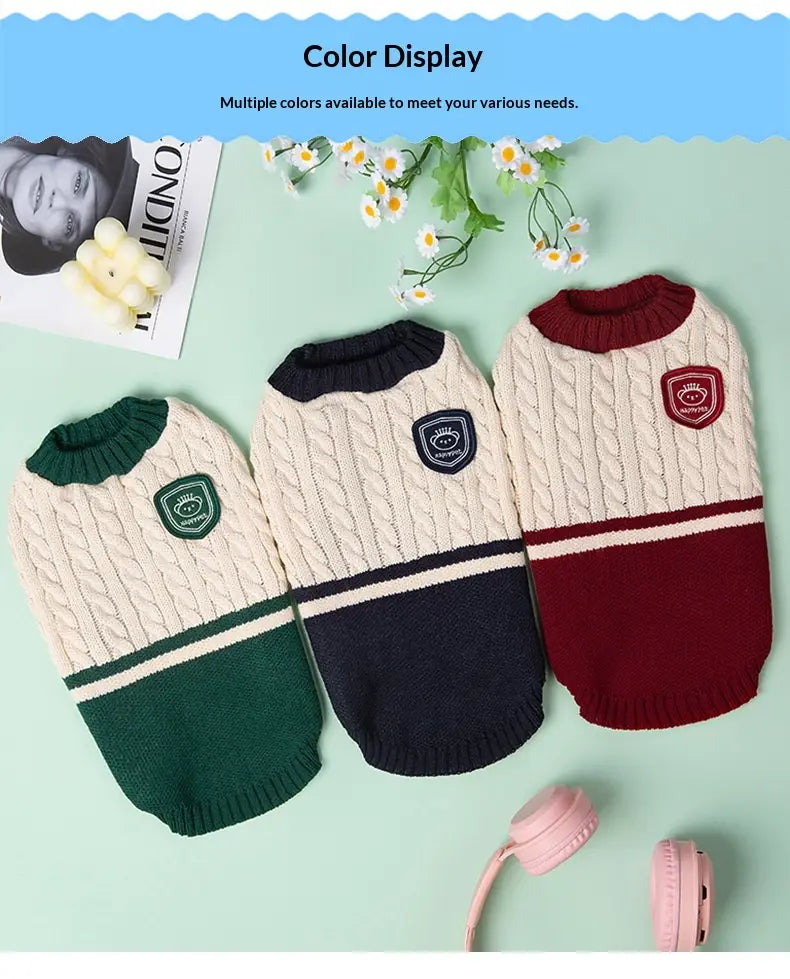 Drei gestrickte Hundepullover in Designs, die sich an Schuluniformen orientieren: mit Zopfmuster, kontrastierenden Farbfeldern und bestickten Aufnähern für warme Tierbekleidung.