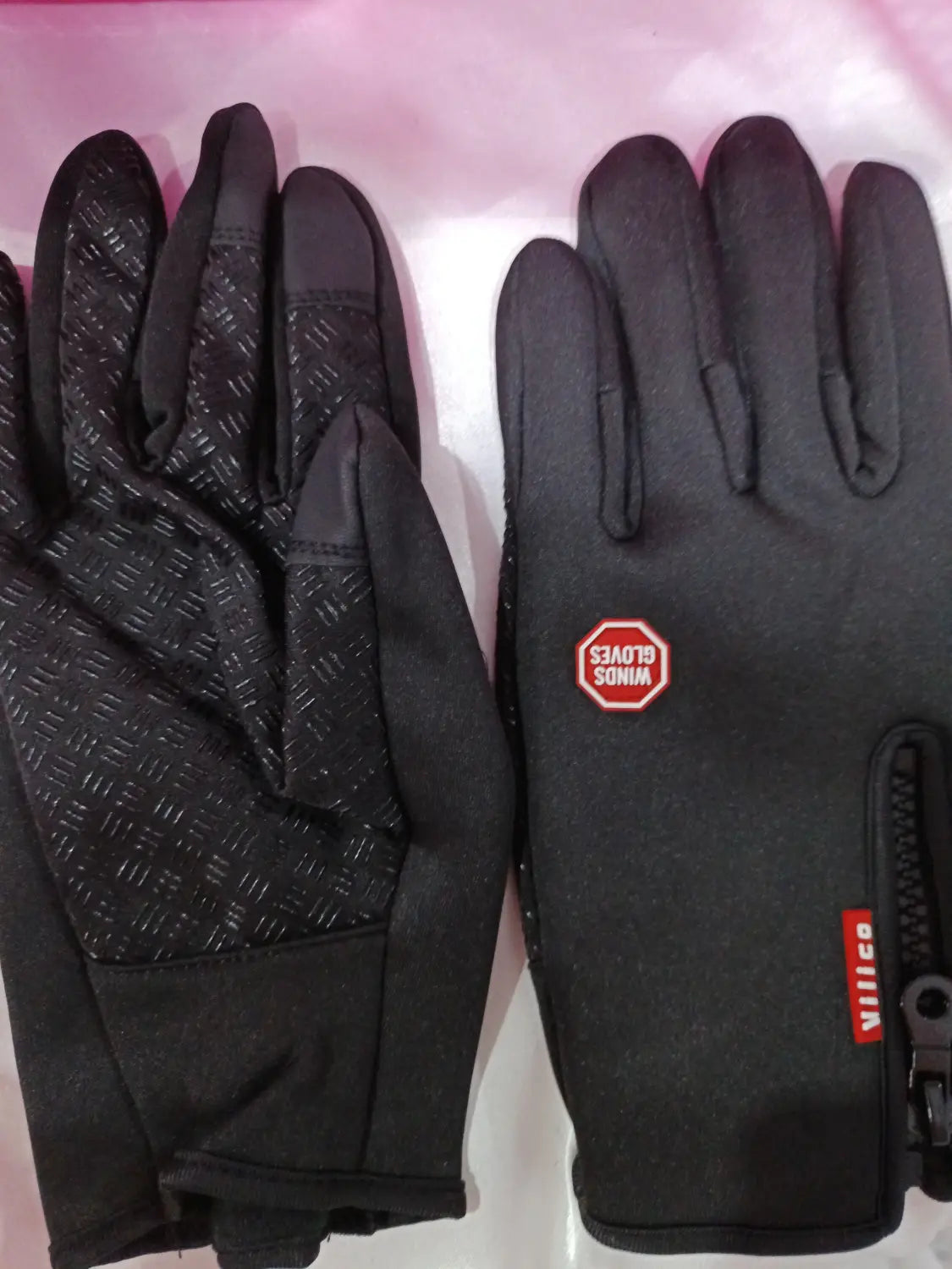 Black windproof touchscreen winter gloves for men and women with textured grip on fingers and palm and red branding patches.
