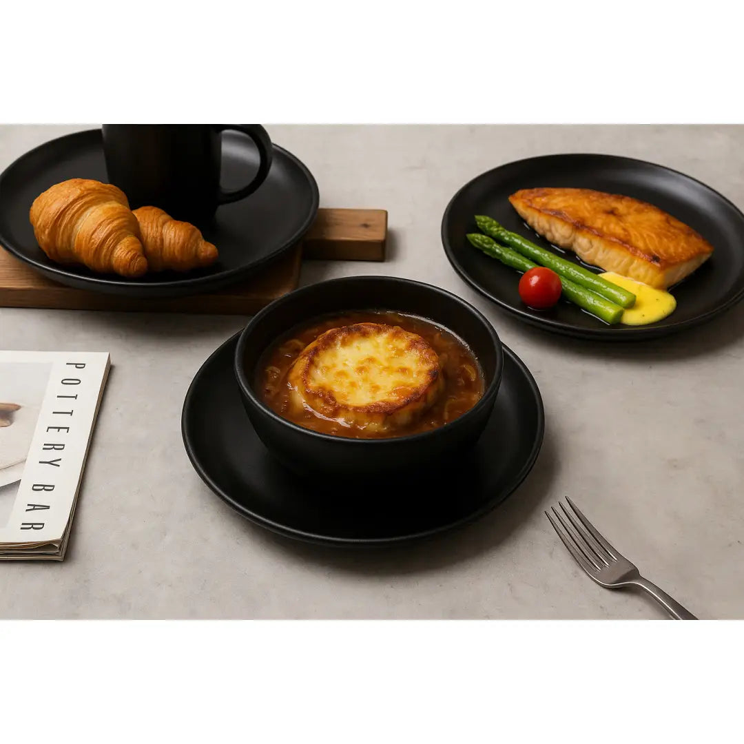 tazón de cerámica negra de un juego de vajilla de gres mate negro de 12 piezas para 3 que contiene sopa de cebolla francesa con una corteza de queso color dorado tostado