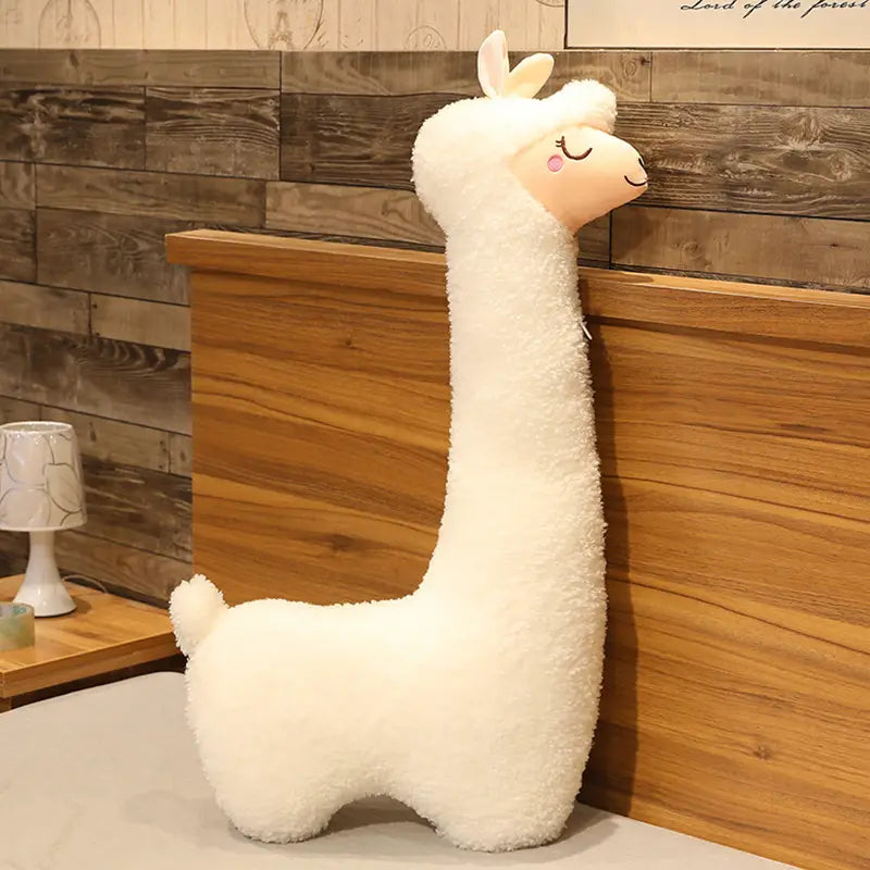 A large white alpaca plush toy pillow measuring 75cm with soft fluffy fur and a cute face featuring closed eyes and pink cheeks.