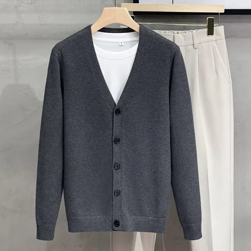 Herren-Strick-V-Neck-Cardigan-Sweater-Mantel in Grau mit schwarzen Knöpfen und gerippten Bündchen aus Strickstoff gefertigt.