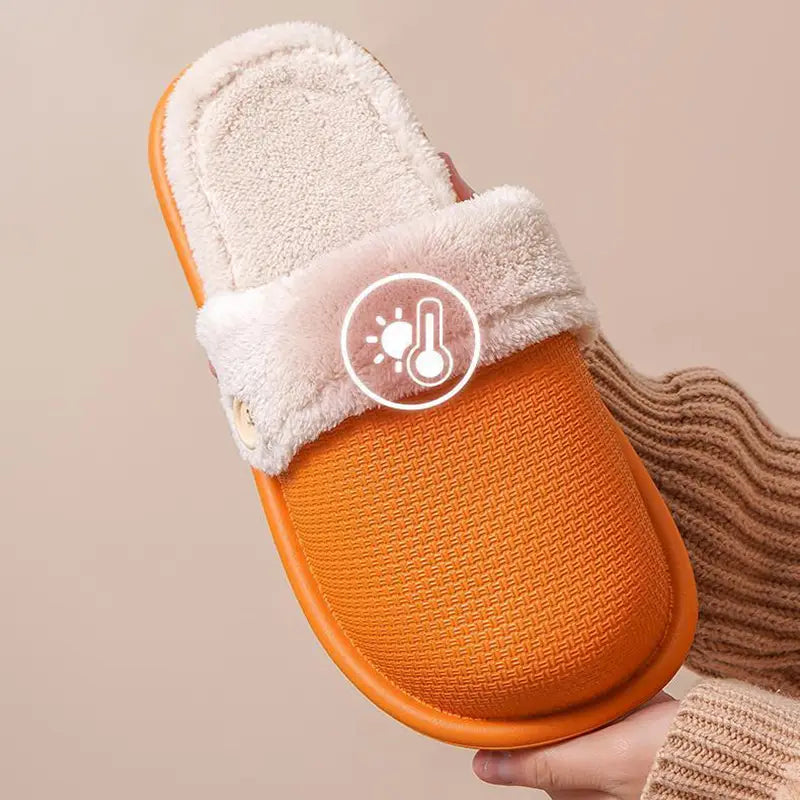 Orange winter slipper for women with a plush white faux fur cuff and textured rubber sole designed as washable plush house shoes.