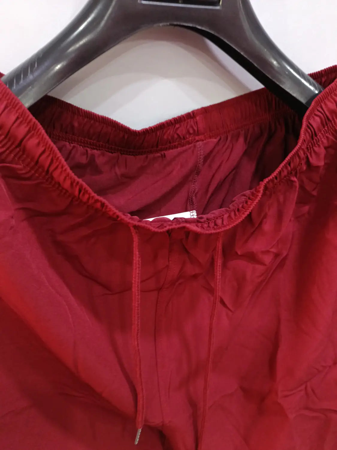 Red drawstring printed men beach shorts with elastic waistband made of smooth lightweight fabric for summer swim trunks.
