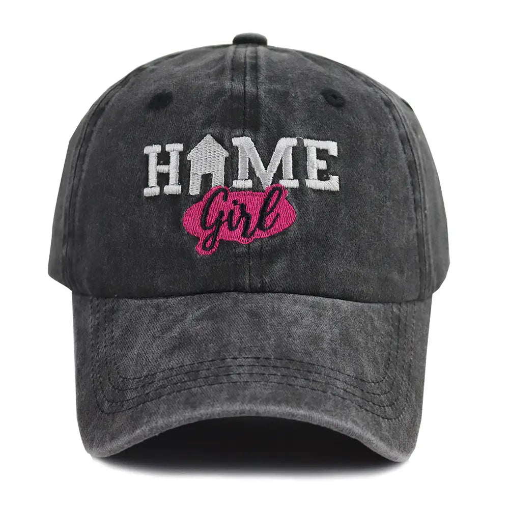 Casquette de baseball noire délavée et usée avec « home » brodé en blanc, et une bulle de dialogue rose contenant le mot « girl ».