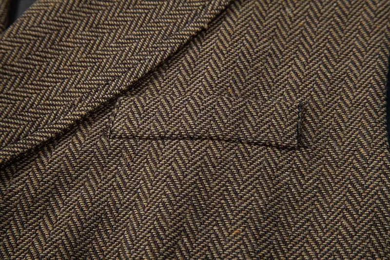 Chaleco de traje tipo sastre doble abotonado de espiga para hombre en lana marrón con textura sutil y patrón clásico de tweed.