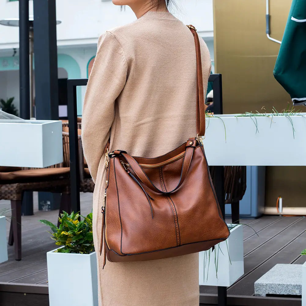 Premium brown leather hobo crossbody bag featuring a structured slouchy design with gold-tone hardware.