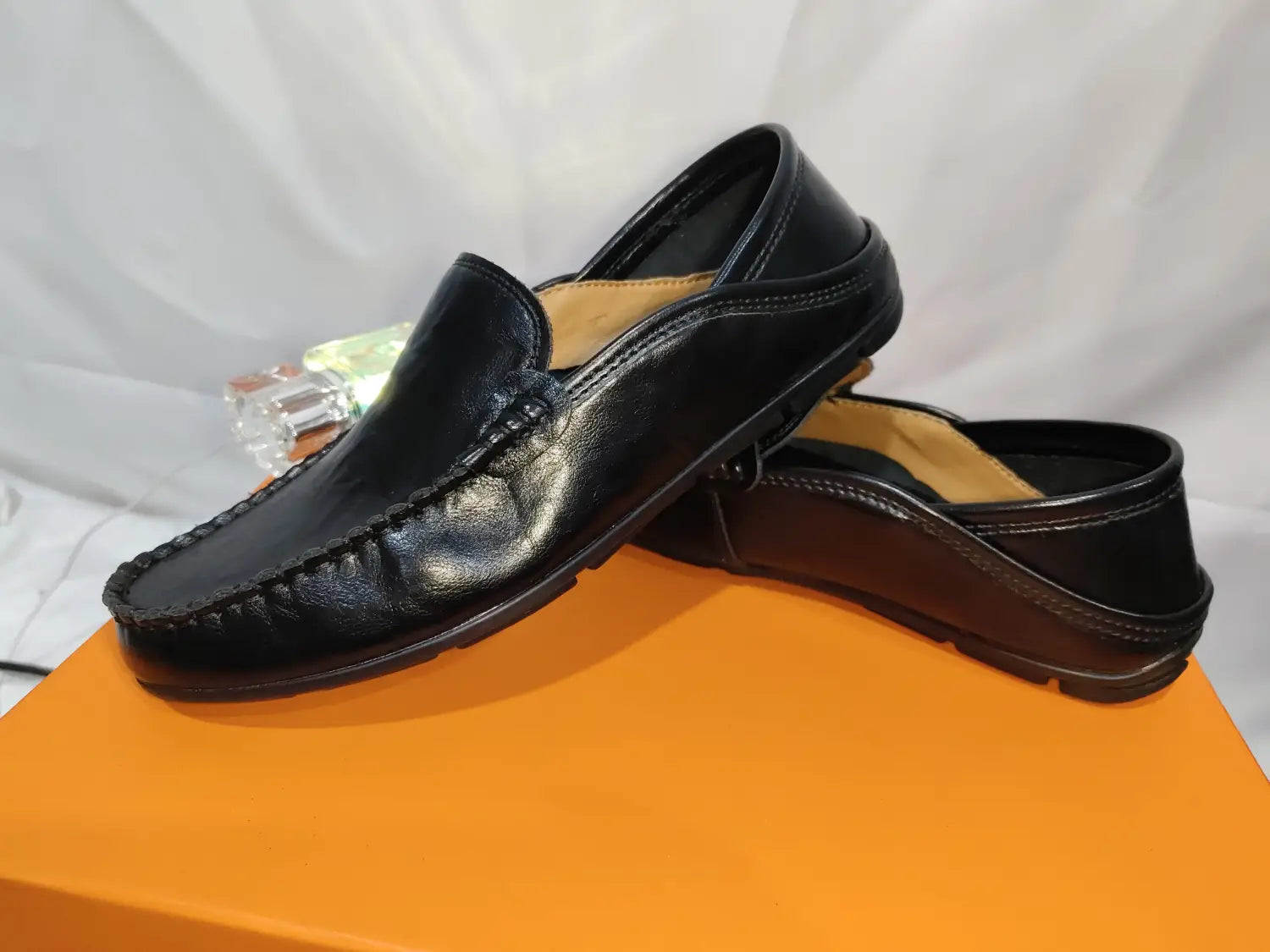 Mocasines tipo alpargata de cuero para hombre en color negro, con acabado liso y brillante y costuras visibles a lo largo de las costuras, adecuados para zapatos de conducción casuales.