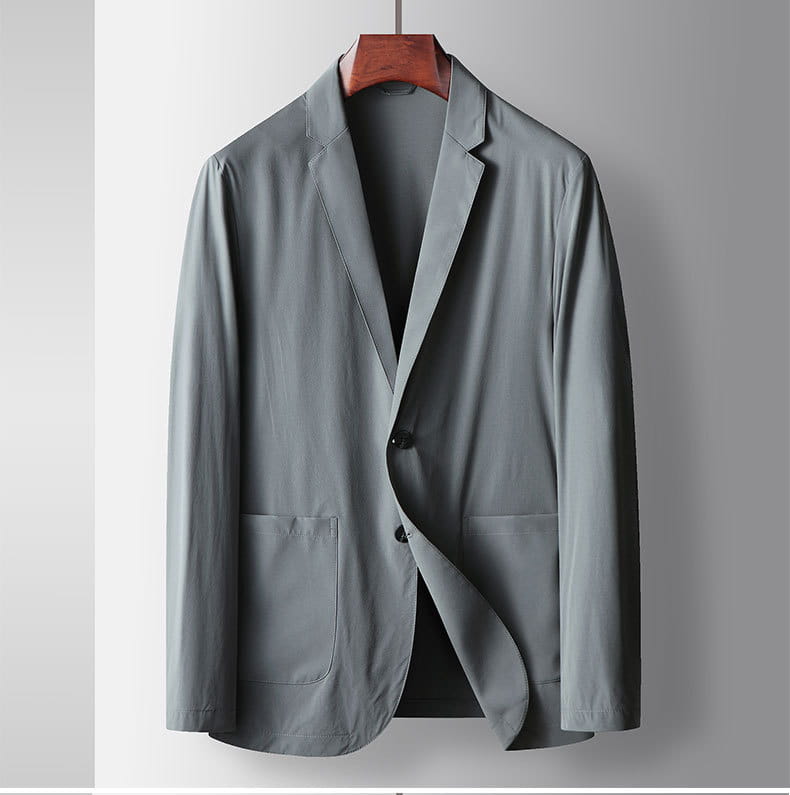 Eine elegante, helle graue Herren-Leichtgewicht-Stretch-Anzugjacke gegen Falten mit modernem Schnitt und dezentem Muster, ordentlich an einem Holzkleiderbügel hängend.