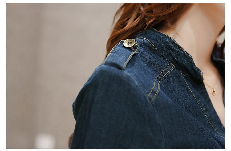 denim jacket with dark blue fabric, visible stitching, and a brass-colored button on the shoulder paired with an elegant high waist button down denim midi dress.