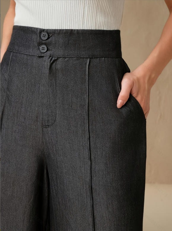 Dark gray high waisted wide leg trousers made of textured fabric with two front buttons.