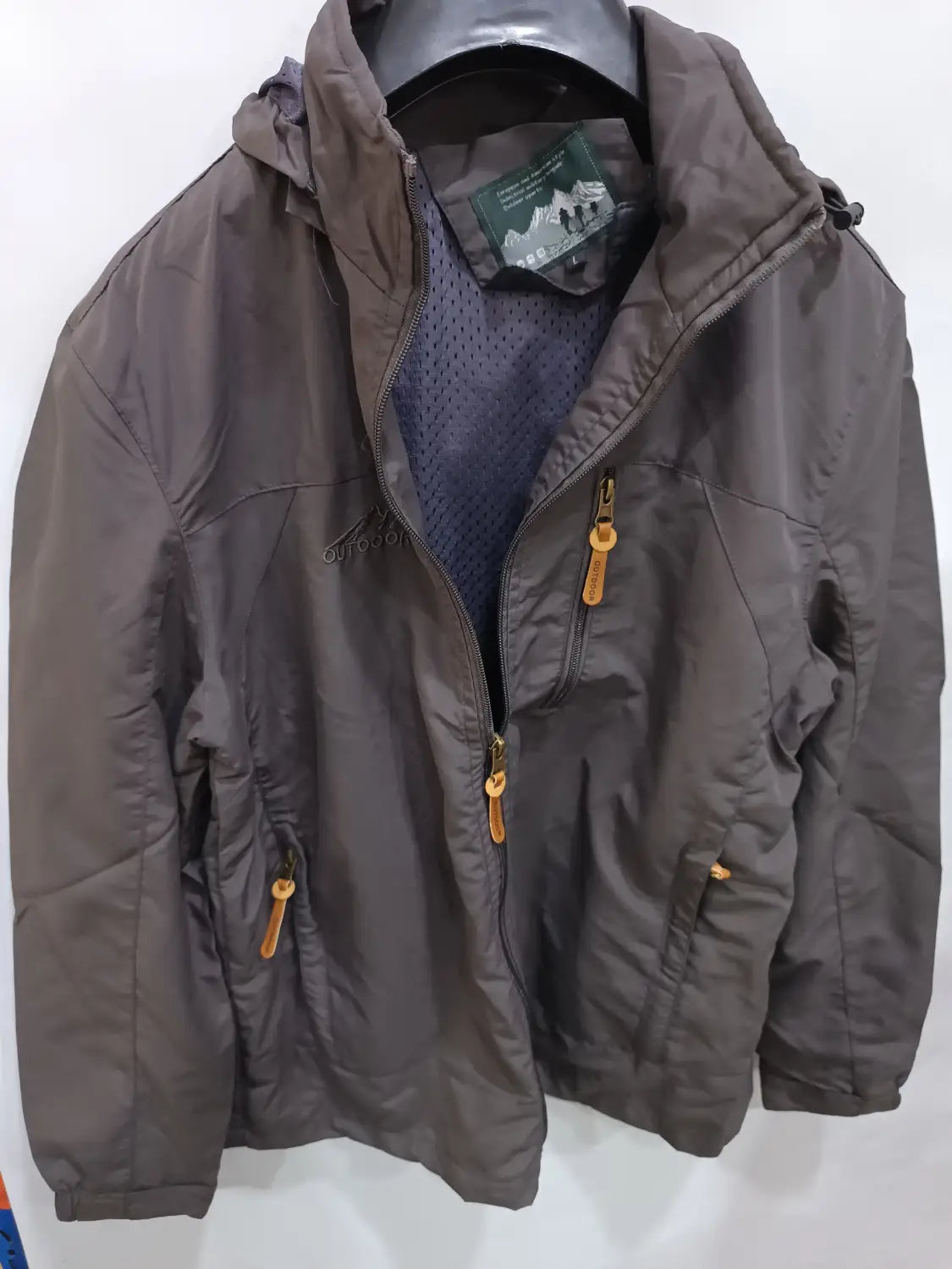 Chaqueta de senderismo con capucha impermeable color gris oscuro, con tiradores de cremallera color camel y un interior forrado con malla.