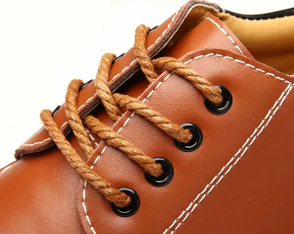Herren-Braunlederschuh zur Höhensteigerung mit 6-cm-Einlegesohle, mit beigen geflochtenen Schnürsenkeln und weißer Steppung.