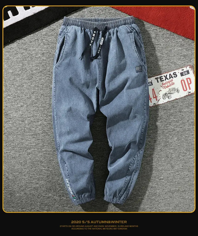Men’s relaxed fit denim joggers in blue with elastic drawstring waistband and subtle stitching details