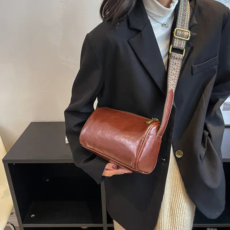 Brown leather retro crossbody bag with a textured woven strap and gold tone hardware.