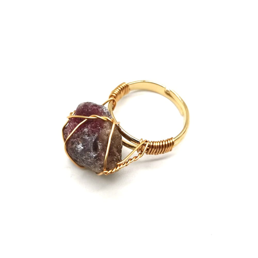Handcrafted gold wire wrapped adjustable ring featuring a raw faceted ruby colored gemstone.