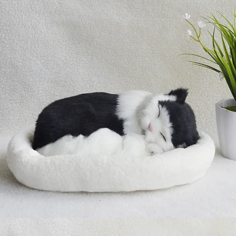 a plush black and white realistic breathing cat figurine nestled in a soft fluffy white pet bed designed for comfort and decoration