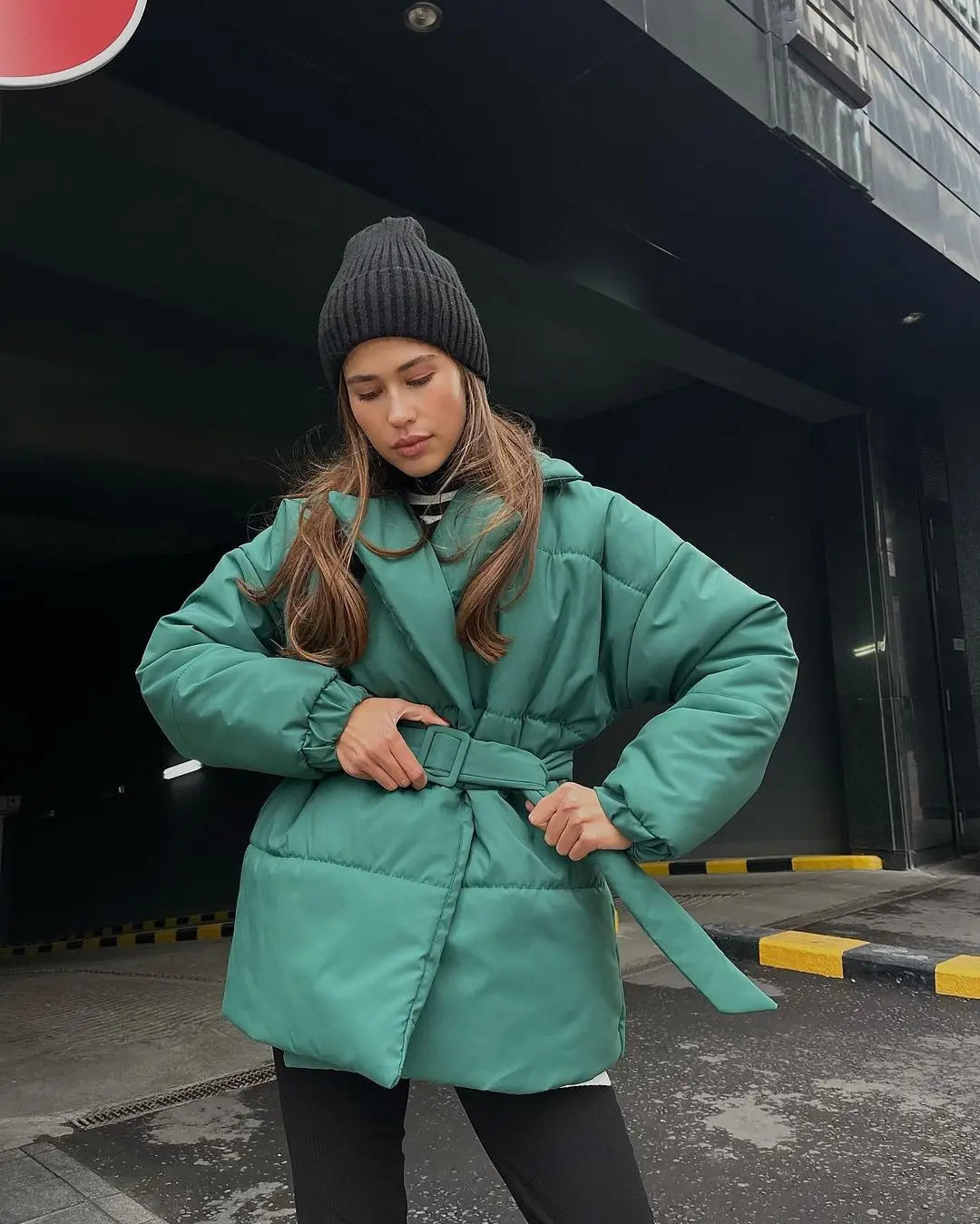 Dunkelblaue Damen-Gurtsteppjacke mit Kapuze, wattierte Pufferjacke für den Winter, mit Taillengürtel und isolierendem Design für kaltes Wetter.