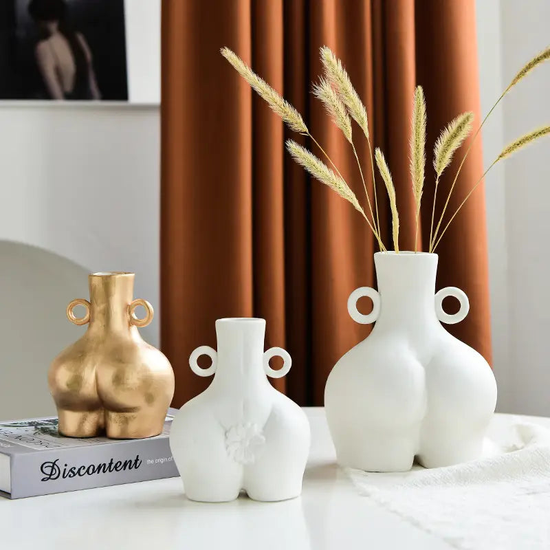 three ceramic vases shaped like buttocks with circular handles in gold and white colors for female body ceramic vase with buttocks design and handles product