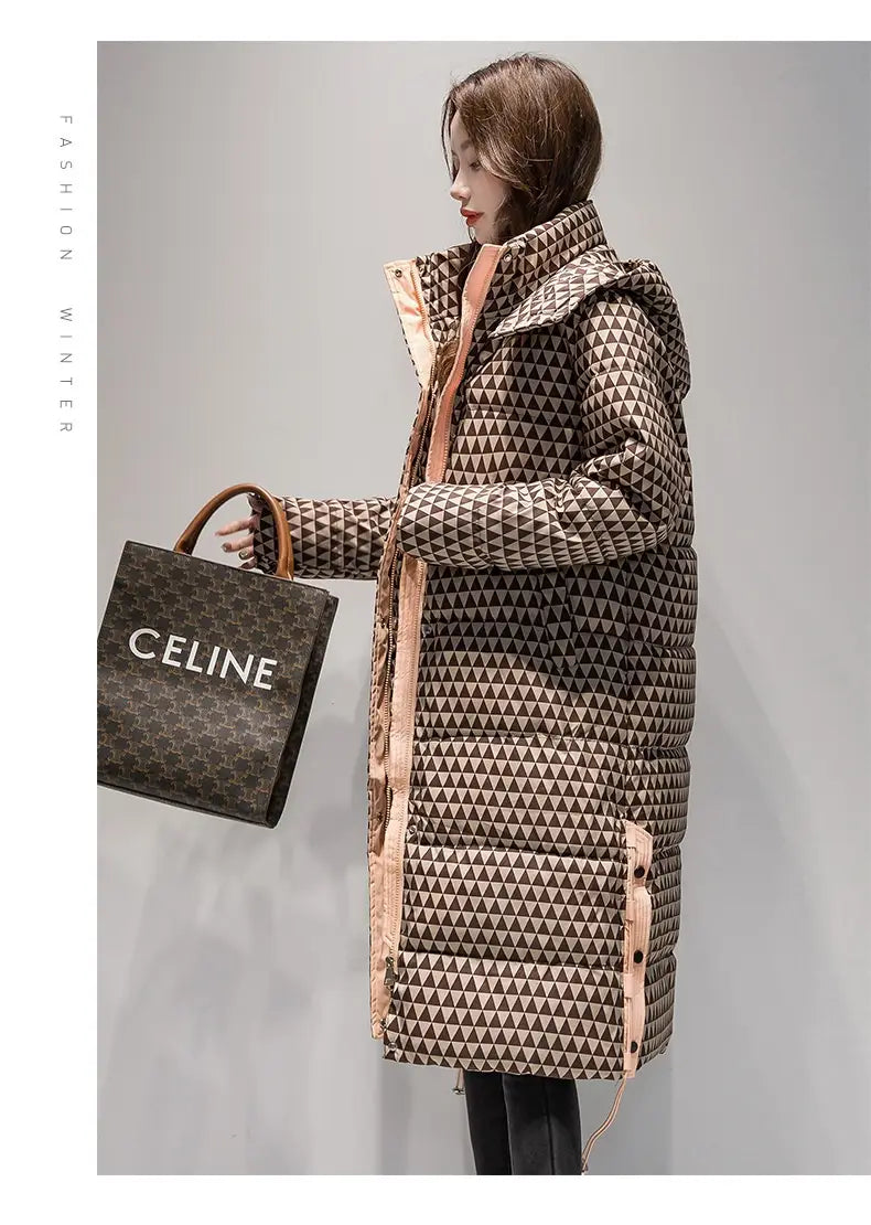 Un long manteau matelassé matelassé à carreaux pour femmes avec un motif pied-de-poule à triangles géométriques dans des tons de marron et de beige, ainsi qu’une finition brun rosé le long des côtés et de la capuche