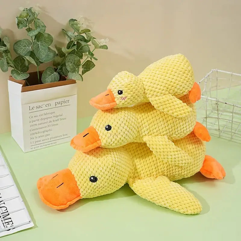 Three stacked yellow crocheted duck plush toys with orange beaks and feet designed as calming duck toys for dogs anxiety relief with quacking feature.