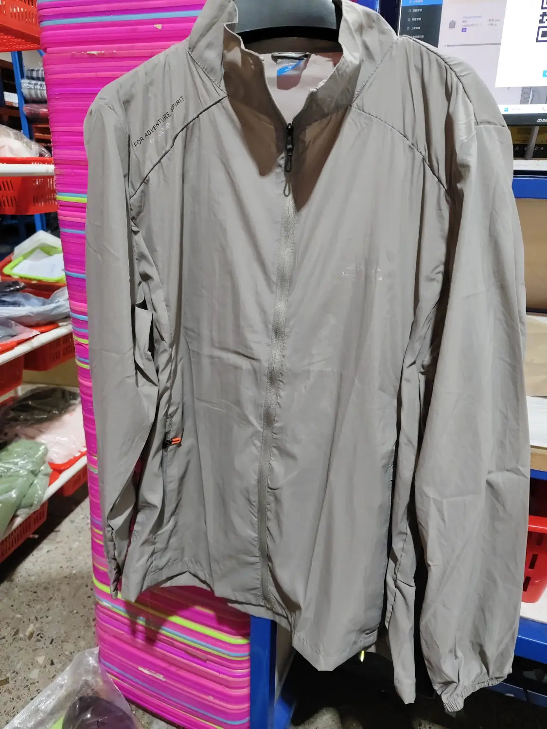Men’s ultrathin sun protective sports jacket in light gray lightweight fabric with zip-up front, subtle logo on the left chest, and elastic cuffs.