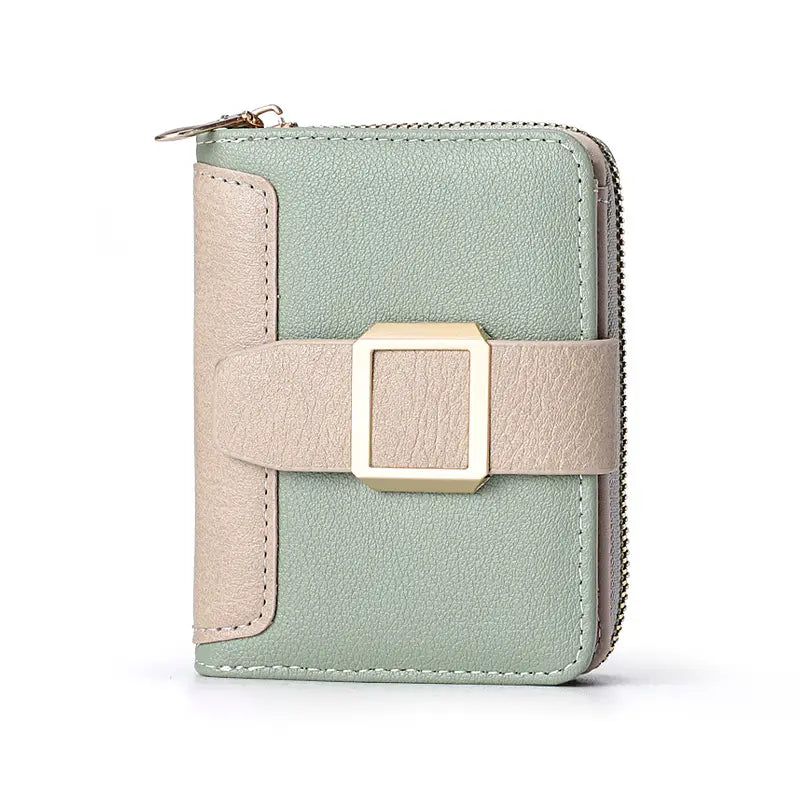 Portefeuille en cuir pour femme, de petite taille, de couleur vert menthe et beige, doté d’une bride à boucle de finition ton sur ton or et d’une fermeture à glissière.